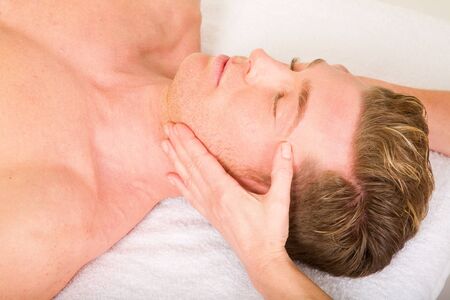 young man receives a face massageの写真素材