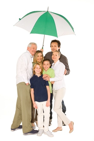 three generations family standing isolated on white background holding umbrellaの写真素材