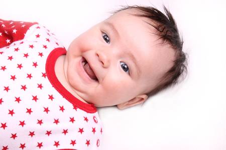 Cheerful little girl lying on white blanket
