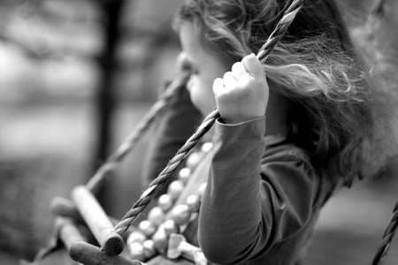 Little girl swinging on a swingの写真素材