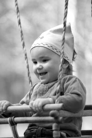 girl swings on a wooden swingの写真素材