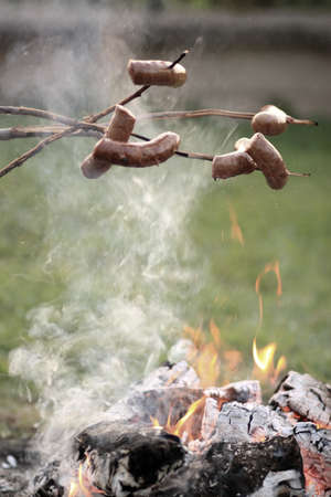 Tasty baked sausage on fire on a summer eveningの写真素材