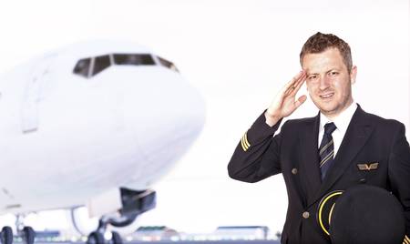 Pilot saluting in front of airplane の写真素材