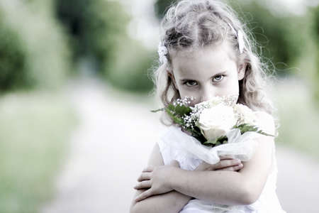 pretty girl smelling flower in the meadowの写真素材