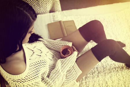 Girl in stockings rests with hot teaの写真素材