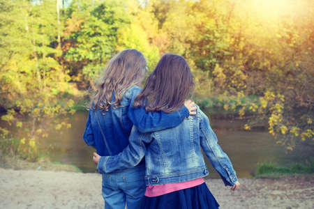 Two friends of children snuggling on a walkの写真素材
