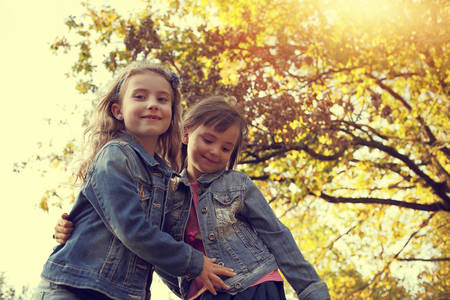 Two young girls having fun in the autumn sunny dayの写真素材