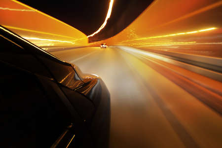 car driving through the city streets at nightの写真素材