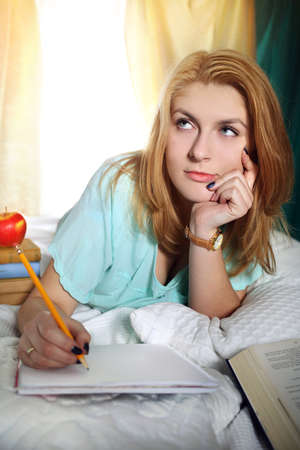 beautiful thoughtful girl learns to test at homeの写真素材