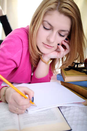 The girl writes a note in notebookの写真素材