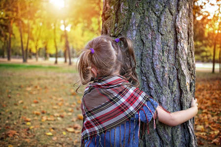 carefree girl embraces a tree in the parkの写真素材