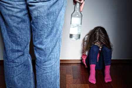 Drunk father standing over a crying daughter