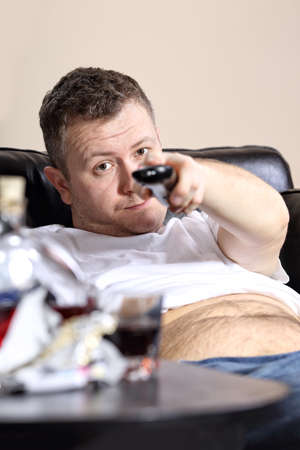 Guy on the couch flips channels on tvの写真素材