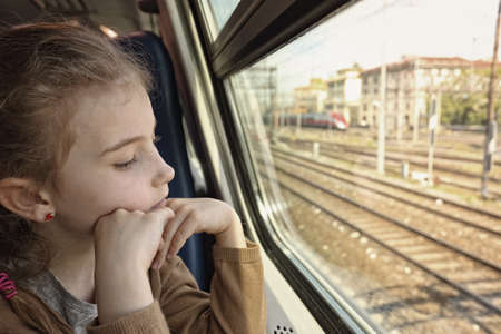 Pensive young girl in trainの写真素材