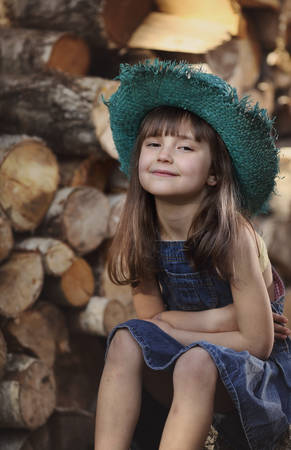Young girl on a farm in a green straw hatの写真素材
