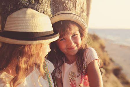 Two sisters in hats on a sunny day
