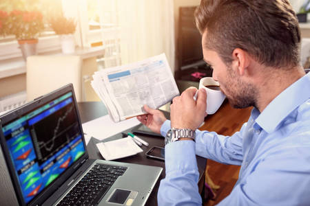 young businessman checks the stock price at home