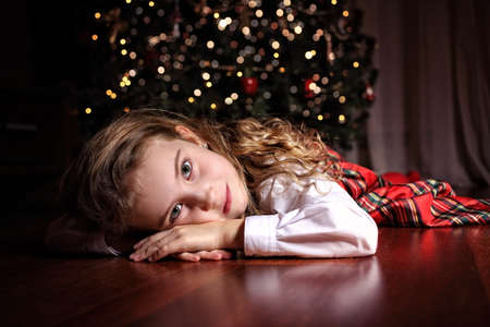 Young pensive girl lying on Christmas Eveの写真素材