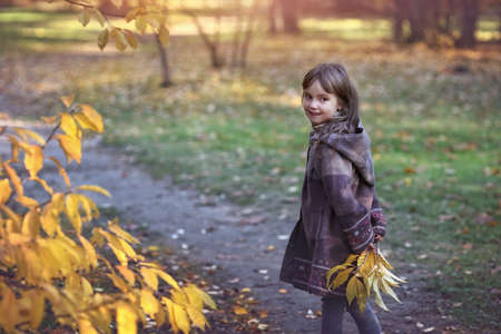 Young girl walk in the autumn park