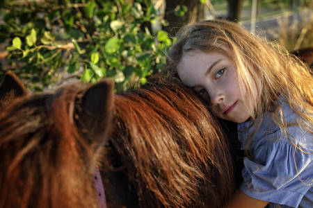 Young girl hugging a horseの写真素材