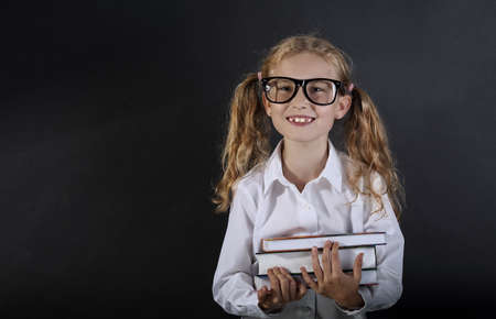 Young schoolgirl in glasses with textbooks
