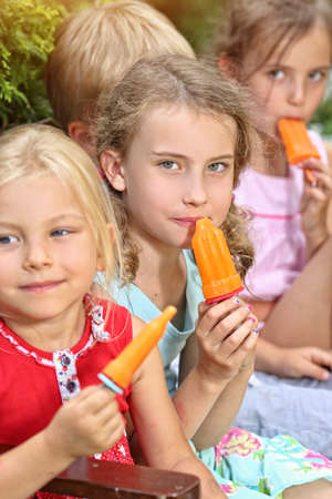 Young friends eat ice cream on a sunny dayの写真素材