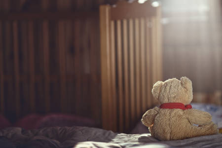 Teddy bear in an empty child's roomの写真素材