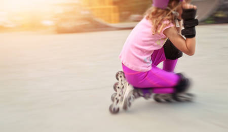 young girl rides on rollers in skate park