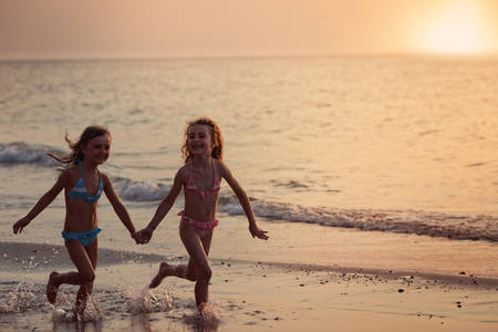 carefree young friends running on the beachの写真素材