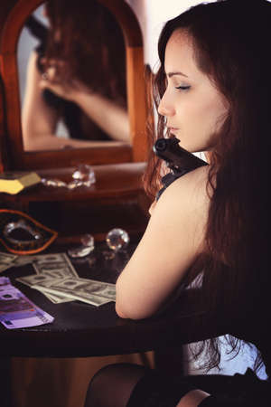 Woman in a room with a gunの写真素材