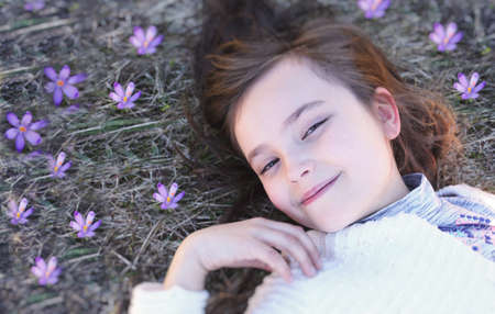 Lovely girl lies in crocusesの写真素材