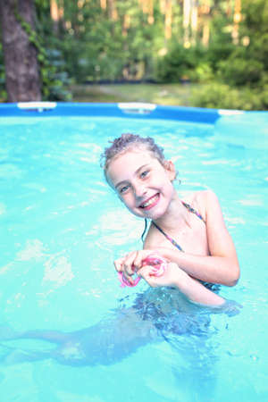 Young girl in the pool in a warm summer dayの写真素材