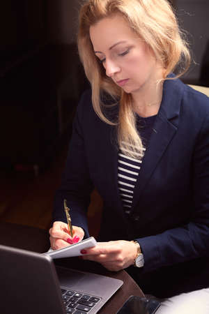 woman is working at home and writes notesの写真素材