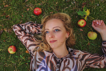 thoughtful woman lies on the grassの写真素材