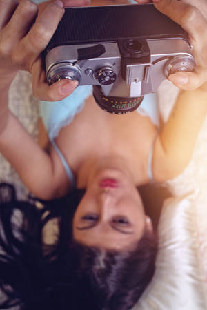 Sensual woman takes a photo of an old cameraの写真素材