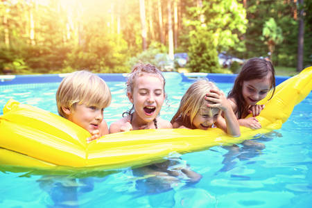 Fun young friends in the garden poolの写真素材