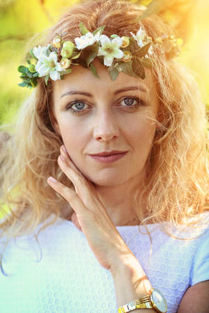 Beautiful girl in a wreath on a sunny dayの写真素材