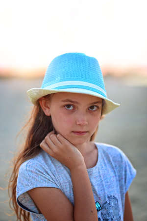 young girl in a hat on a sunny day at the beachの写真素材