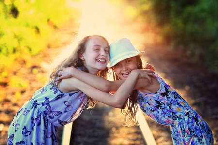 happy sisters laugh on a sunny dayの写真素材