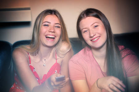 young friends are watching a movie together on tv