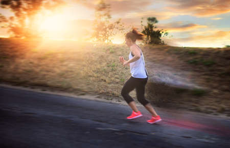 Shapely and athletic girl runs on a sunny day outsideの写真素材