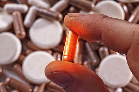 glowing medicine capsule against the background of other drugs