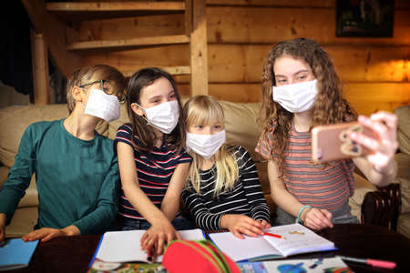 children take pictures wearing masks locked in their homes by a coronavirus pandemicの写真素材