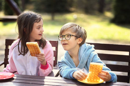 young friends laugh outside at breakfastの写真素材
