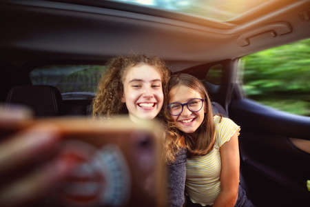 young girls in the car taking a selfie photo of themselves