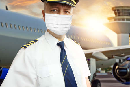 Airplane captain pilot in mask on airportの写真素材