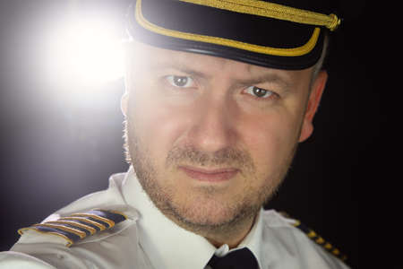 captain of the plane pilot in uniform with stubbleの写真素材