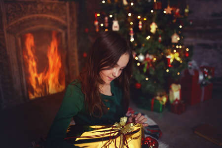 A young girl opens a Christmas giftの写真素材