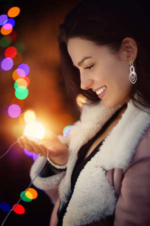 Portrait of a young girl smiling on a cold winter eveningの写真素材