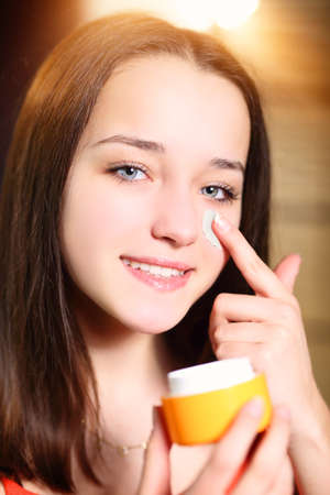 smiling teenage girl doing her morning cosmetic routine